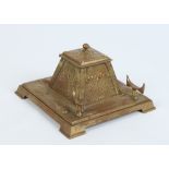 An Art Nouveau gilt bronze desk stand of stylized square form. With hinged inkwell and raised on