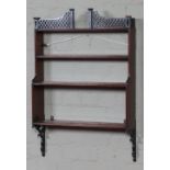 A nineteenth century mahogany four tier waterfall wall shelf. With pierced trellis gallery and