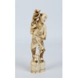 A Japanese carved ivory okimono. Formed as a man with a monkey upon his shoulders and with a