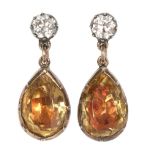 A pair of gold drop earrings each set with a brilliant cut diamond, a foil backed tear cut citrine