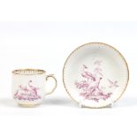 A Chelsea cup and saucer. With gilt borders and delicately enamelled in puce camaieu with birds.