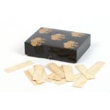A Japanese Meiji period lacquer small games box with hiramaki decoration, having miniature bronze
