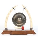 A late nineteenth century Indian carved ivory dinner gong on breakfront mahogany plinth and with