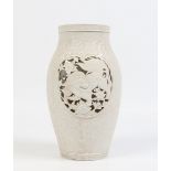 A Chinese blanc de chine ovoid vase. Moulded with scrolls over a textured ground and with two