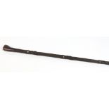 A Maori hardwood staff. Carved to the shaft with three figures having mother of pearl inset eyes and