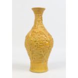 A Chinese yellow glazed baluster vase. Decorated in relief over a ground of cloud scrolls with two