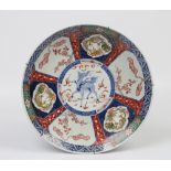 A Japanese Meiji period Imari charger. Decorated to the centre with a kirin and panels of dragons