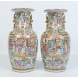 A pair of early nineteenth century Cantonese vases. With moulded gilt handles and painted with