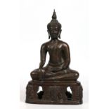 An Eastern bronze figure of a seated Buddha, possibly Thai. Raised on an openwork plinth decorated