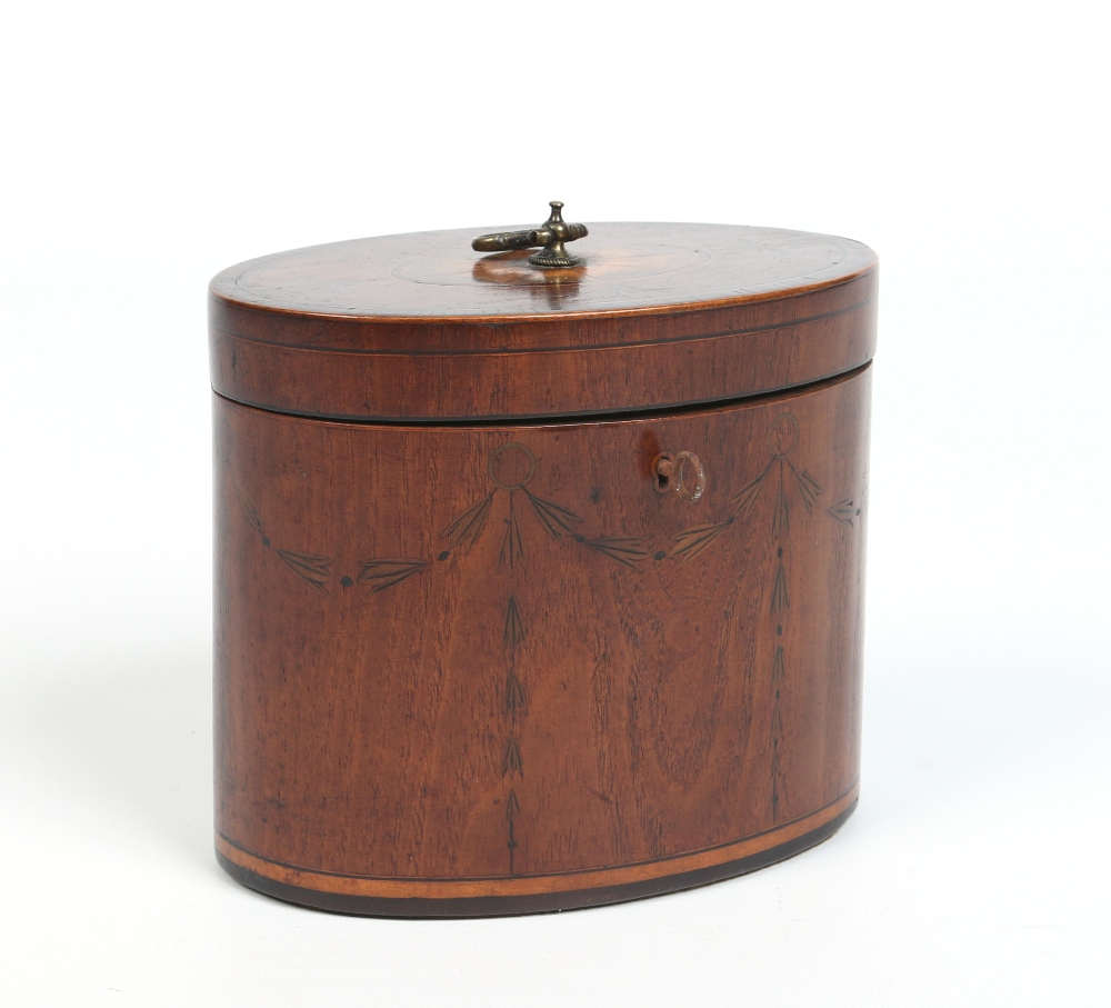 A small Regency oval mahogany tea caddy. With brass loop handle, banded in rosewood and with a