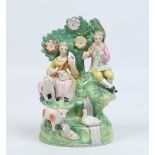 A Staffordshire pearlware arbour group coloured in enamels. Modelled as a young Shepherd and