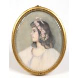 An early twentieth century oval ivory portrait miniature of a young girl in brass strut frame, 10cm.