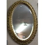 A gilt framed bevel edged oval wall mirror.