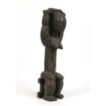 A large African carved hardwood Atye statue of a seated tribeswoman with metal stud work, 50cm high.