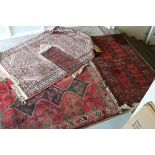 Three wool rugs and a similar small runner largest 153 cm x 120 cm three red ground and one pink.