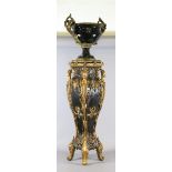 A decorative gilt metal twin handle urn on stand.