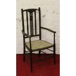 An Edwardian inlaid mahogany slatback armchair raised on tapering supports.