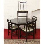 A mahogany extending circular table with inbuilt leaf along with four slat back chairs by Stag