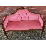 A carved mahogany parlour settee in the French style raised on slender cabriole supports.