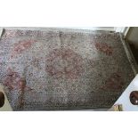 A Kashmir silk rug 270 cm x 184 cm cream ground and with a red medallion and spandrels.