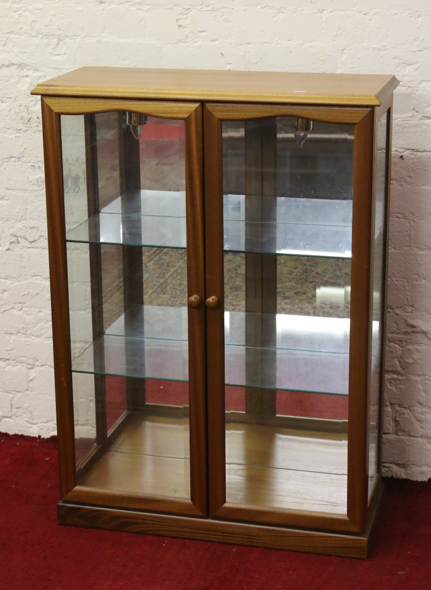 A light oak display cabinet with bevel edge glass.