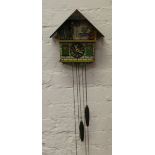 A carved and painted cased cuckoo clock lacking pendulum.