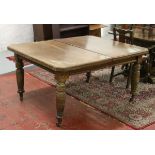 A Victorian oak wind out dining table with canted corners and raised on turned supports.