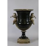 A large bronzed based twin handle urn decorated with cherubs.