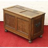 A carved and panelled oak blanket box raised on bun feet.