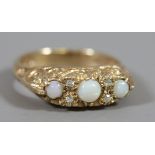 A 9 carat gold ring with scrollwork shank and set with three opals, ring size O.