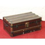 An antique wooden bound travel trunk with carrying handles.