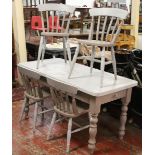 A painted pine kitchen table and four slat back chairs, stencilled for vintage imperial champagne.