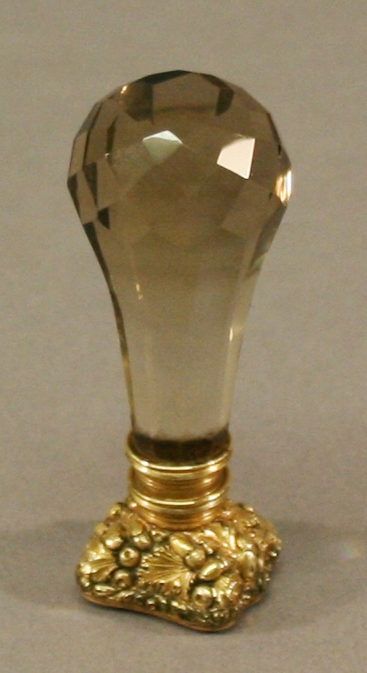 A 19TH CENTURY GLASS, GILT METAL AND CARNELIAN SEAL with facet-cut glass handle, yellow metal