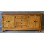 AN ALAN GRAINGER 'ACORN INDUSTRIES' OAK SIDEBOARD having an oblong adzed top, a central bank of four