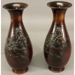 A PAIR OF JAPANESE BRONZE VASES of baluster form with flared rims, moulded with macaque monkeys.