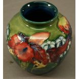 A MOORCROFT POTTERY 'IRIS' PATTERN VASE of globular form, tube-lined with flowers against a washed