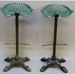 A GROUP OF FOUR TRACTOR SEAT BAR STOOLS, the green painted tractor seats mounted to cast iron bar