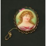 AN EDWARDIAN 9CT GOLD MOUNTED & HAND-PAINTED PORCELAIN BROOCH of oval form decorated with a portrait