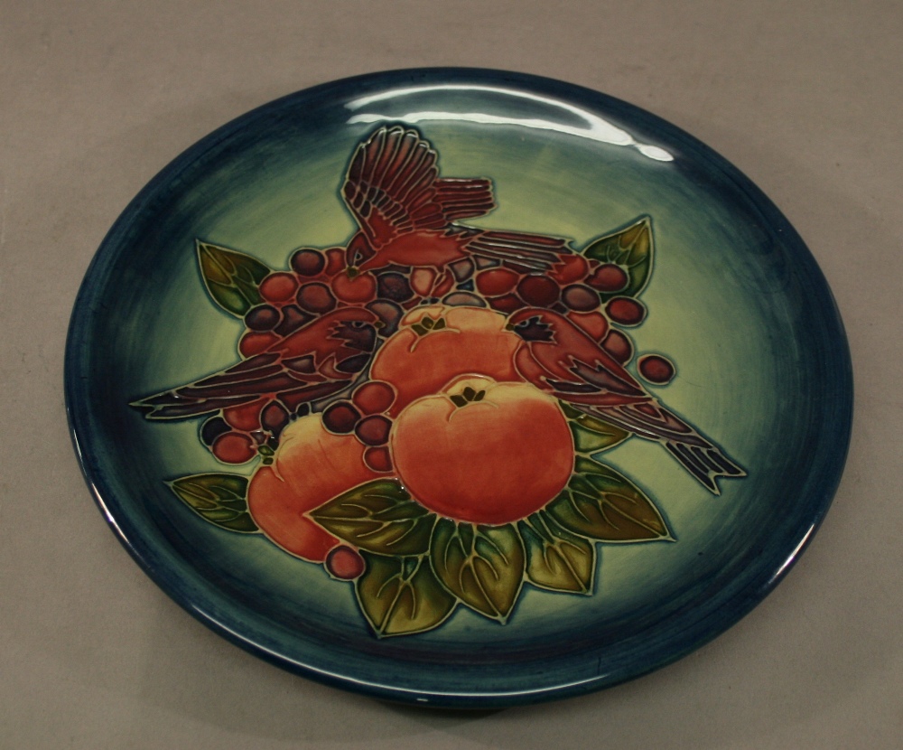 A MOORCROFT POTTERY 'FINCHES' PATTERN PLATE tube-lined with birds and fruit, washed blue ground,