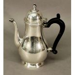 A SMALL SILVER PLATED HOT WATER POT of baluster form with domed finial topped cover, shaped handle