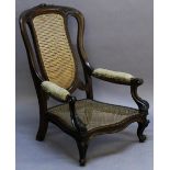 A 19TH CENTURY BERGERE ARMCHAIR having a shaped back with carved foliate crest, central caned