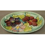 A MOORCROFT POTTERY 'CLEMATIS' PATTERN DISH of oval form, tube-lined with flowers against a washed