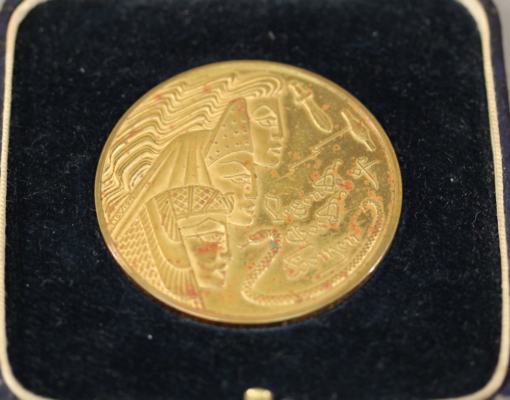 A GILT  BRONZE MEDALLION with art deco Egyptian revival decoration, the obverse with biblical scene,