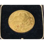 A GILT  BRONZE MEDALLION with art deco Egyptian revival decoration, the obverse with biblical scene,