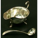 A GEORGE V SILVER SAUCE BOAT of typical ovoid form with moulded rim, scroll handle and three