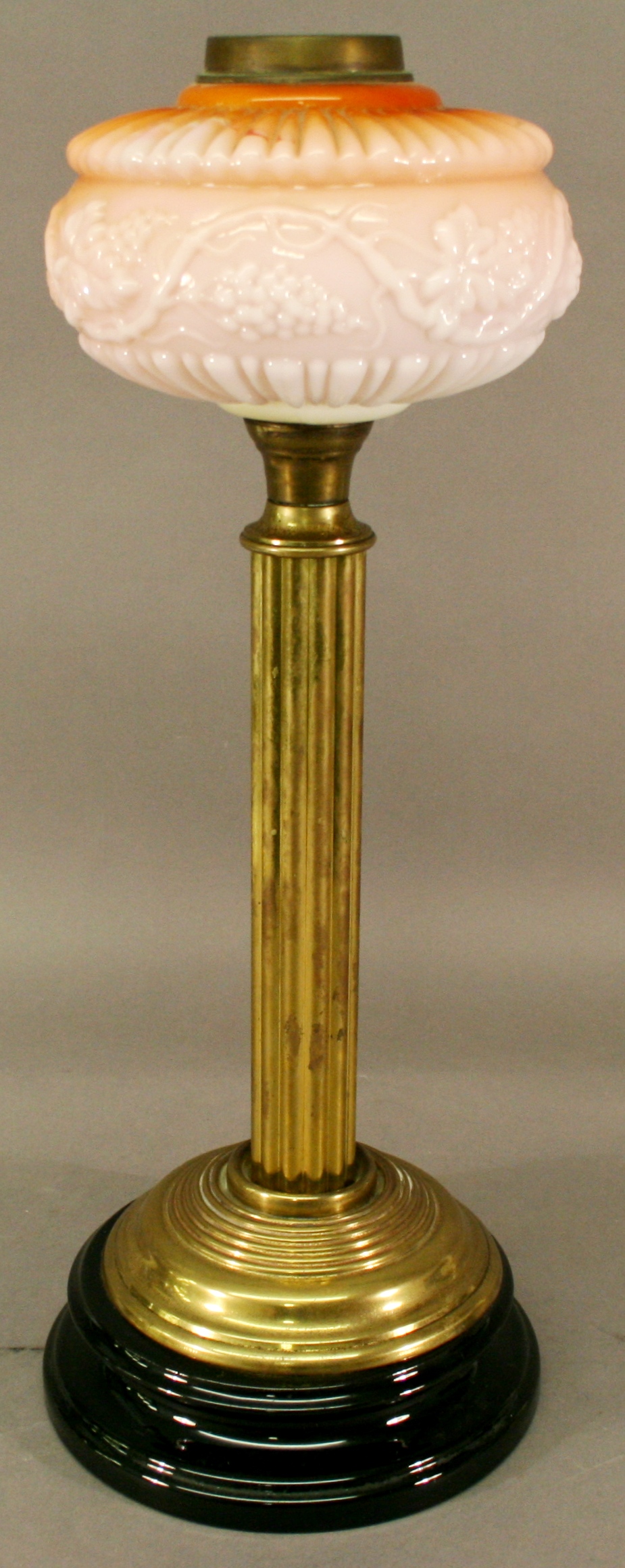 A VICTORIAN BRASS AND GLASS COLUMN OIL LAMP having a tinted globular shade, brass burner and moulded