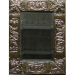 AN ARTS AND CRAFTS COPPER FRAMED MIRROR having a bevelled rectangular plate in a hand-beaten and