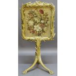 A 19TH CENTURY GILT-WOOD FIRESCREEN the floral needlework panel within a foliate giltwood