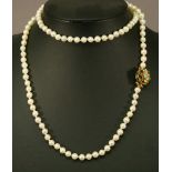 A 9CT GOLD AND PEARL NECKLACE with matching bracelet, the uniform string of pearls ending with a