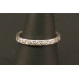 A WHITE METAL AND DIAMOND FULL ETERNITY RING set with multiple small diamond brilliants, unmarked,